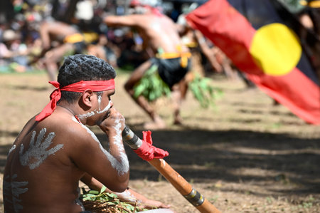 LAURA,QLD - JULY 08 2023:Indigenous Australians men carry the Australian Aboriginal Flag in Laura Quinkan Dance Festival Cape York Queensland Australia.The flag have special legal and political statusのeditorial素材