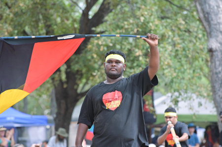 LAURA,QLD - JULY 08 2023:Indigenous Australians men carry the Australian Aboriginal Flag in Laura...