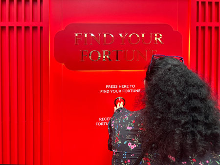 BRISBANE - FEB 02 2024:Person using a find your fortune machine for the New Chines Year.The Chinese...