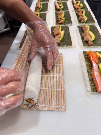 Japanese sushi chef prepare many Sushi, portioned prepared vinegared rice topped or rolled with other ingredients Japanese dish on kitchen countertop.の写真素材