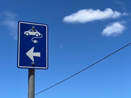 Plug-in electric vehicle sign connect to a cable under clear blue sky with white cloud.の写真素材