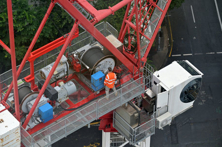 Aerial drone landscape view of team of unrecognizable crane operator fixing lift cable working in...