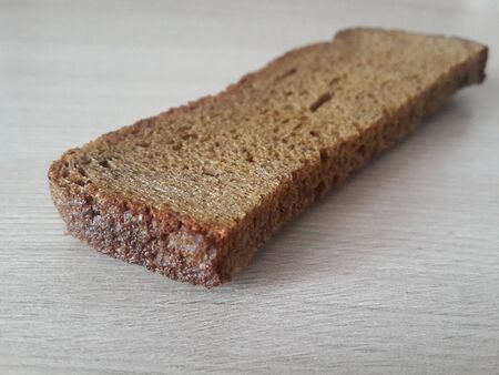 a piece of black bread on a wooden background
