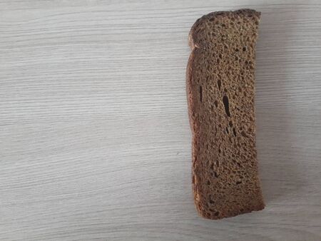 a piece of black bread on a wooden background