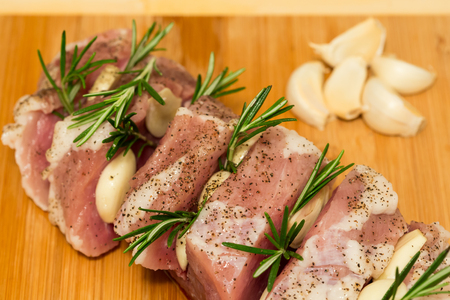Baked pork steak with potato wedges on wooden platterの写真素材