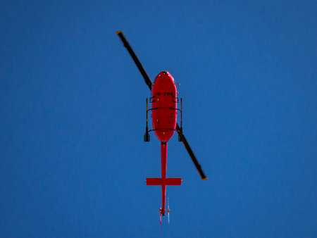 Red helicopter flying into action.の写真素材