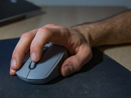 Male hand works with wireless mouse on table.の写真素材