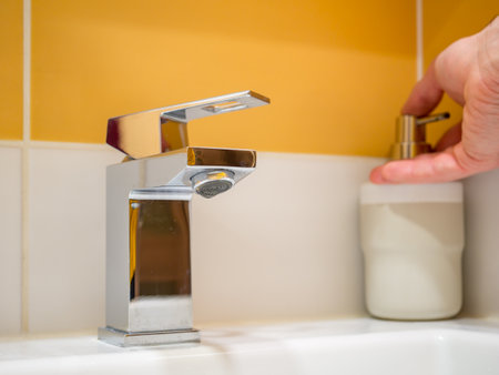 Using a soap dispenser for a basin with a square faucet.の写真素材