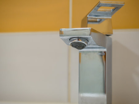 Running water from a square faucet in a modern bathroom.の写真素材