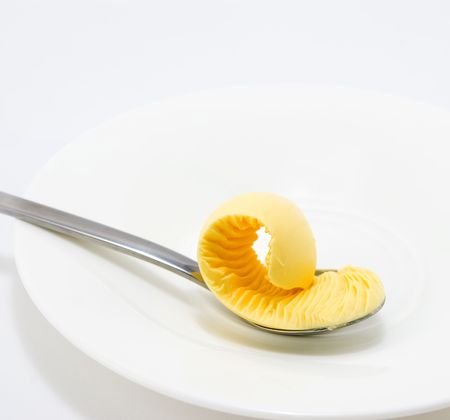 Lemon ice cream on a silver spoon and white plateの写真素材