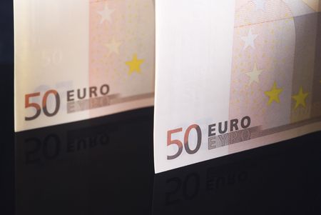 Euro banknotes arranged on black reflective backgroundの写真素材