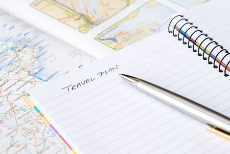 Spiral notebook with silver pen arranged on a mapの写真素材