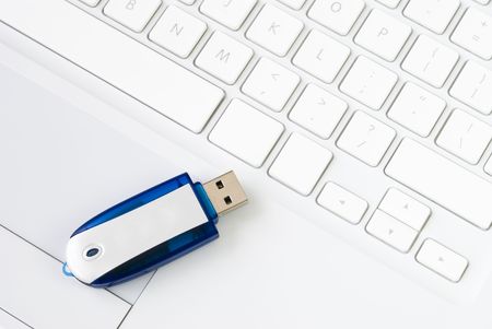 Pen drive arranged on laptop white keyboard