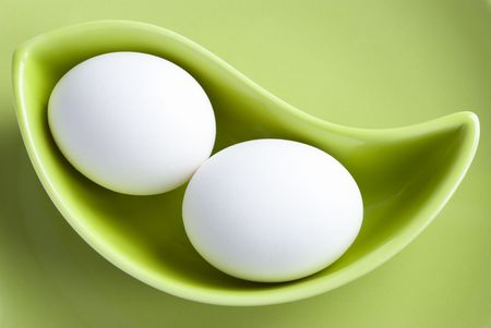 White eggs in a green saucer plate captured from aboveの写真素材