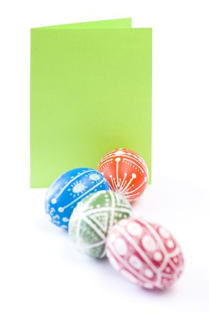 Colorful Easter eggs with blank paper copy space isolated on white backgroundの写真素材