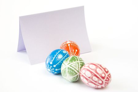 Colorful Easter eggs with blank paper copy space isolated on white backgroundの写真素材