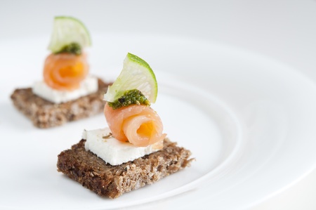 Brown bread salmon appetizer with feta cheese, lime and pestoの写真素材