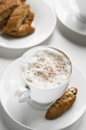Cup of white coffee with cantuccini cookiesの写真素材