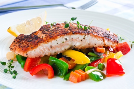 Grilled salmon with vegetables, herbs and lemonの写真素材