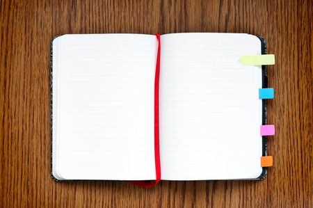 Open notepad on wooden table with copy space