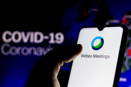 April 8, 2020, Brazil. In this photo illustration the Cisco WebEx Meeting logo seen displayed on a smartphone with a computer model of the COVID-19 coronavirus in the background.のeditorial素材