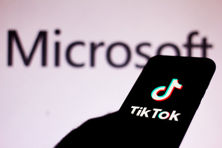 August 7, 2020, Brazil. In this photo illustration the TikTok logo seen displayed on a smartphone. In the background the Microsoft Corporation logoのeditorial素材