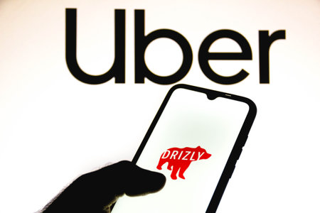 February 4, 2021, Brazil. In this photo illustration the Drizly logo seen displayed on a smartphone screen with the logos of Uber in the backgroundのeditorial素材