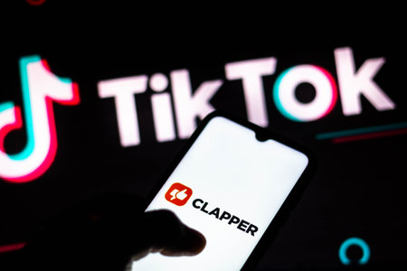 February 2, 2021, Brazil. In this photo illustration the Clapper logo seen in the background of a silhouette hand holding a mobile phoneのeditorial素材