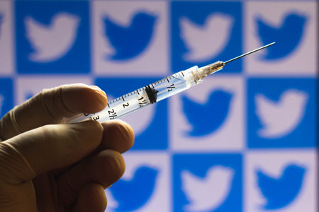 January 27, 2021, Brazil. In this photo illustration medical syringe seen with Twitter logo displayed on a screen in the backgroundのeditorial素材