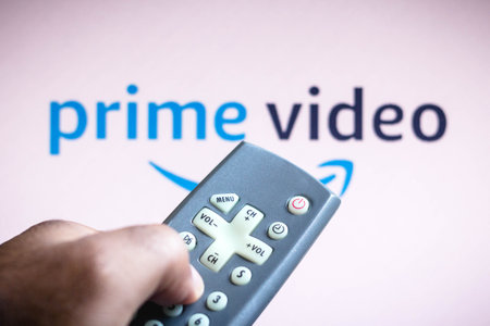 June 3, 2021, Brazil. In this photo illustration a person holds the TV remote control and in the...