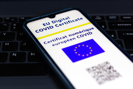 July 13, 2021, Brazil. In this photo illustration the EU Digital COVID Certificate seen on a smartphone screen. In the background, the flag of the European Unionのeditorial素材