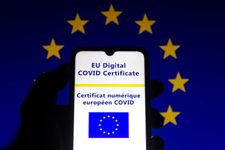 July 13, 2021, Brazil. In this photo illustration the EU Digital COVID Certificate seen on a smartphone screen. In the background, the flag of the European Unionのeditorial素材