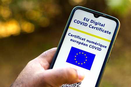 July 13, 2021, Brazil. In this photo illustration the EU Digital COVID Certificate seen on a smartphone screen. In the background, the flag of the European Unionのeditorial素材