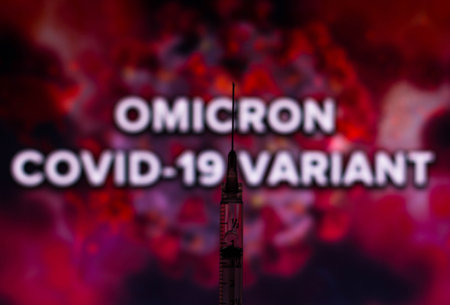 November 29, 2021, Brazil. In this photo illustration medical syringes are seen displayed in front of the words the micron covid-19 variant displayed on a screenのeditorial素材