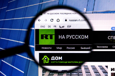 March 2, 2022, Brazil. In this photo illustration, a seen displayed on a computer screen through a magnifying glass and in the background, the flag of Russiaのeditorial素材