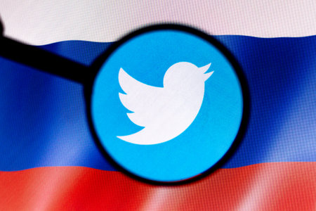 March 2, 2022, Brazil. In this photo illustration, a seen displayed on a computer screen through a magnifying glass and in the background, the flag of Russiaのeditorial素材