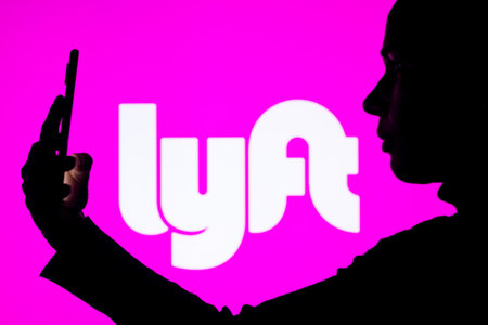 April 1, 2022, Brazil. In this photo illustration, a woman's silhouette holds a smartphone with the Gojek displayed on the screenのeditorial素材