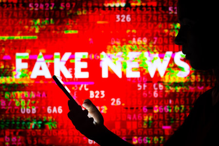 April 5, 2022, Brazil. In this photo illustration, a woman's silhouette holds a smartphone with the IBGE (Brazilian Institute of Geography and Statistics) in the backgroundのeditorial素材