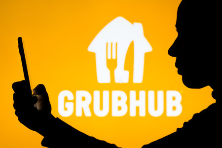 April 18, 2022, Brazil. In this photo illustration, a woman holds a smartphone with the Deliveroo...