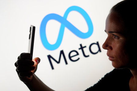 May 15, 2024, Brazil. In this photo illustration, the woman holding a smartphone and the Meta Platforms, Inc. logo is seen in the backgroundのeditorial素材