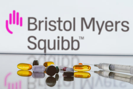 May 27, 2024, Brazil. In this photo illustration, the Bristol-Myers Squibb (BMS) logo is displayed on screen in the background with pills and medical bottle and syringeのeditorial素材