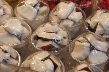 Coconut sliced put in covered plastic cups in Mercado de la Boqueria. Food concept