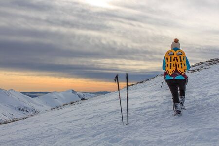 Girl with backpack in the mountains with snow. Lifestyle conceptの写真素材