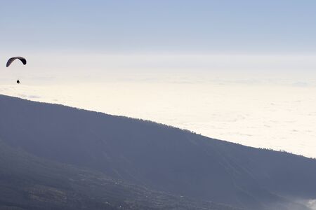 Paragliding above the cloudsの写真素材