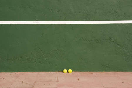 Two yellow tennis balls near the tennis wallの写真素材