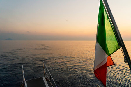Italian Flag on a boat during sunsetの写真素材