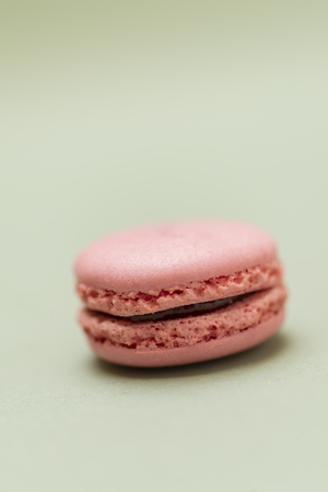 Vintage pastel colored French macaroons or macarons on green backgroundの写真素材