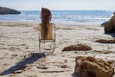 Side view of Trunk doll on beach chair simulating a person sunbathingの写真素材
