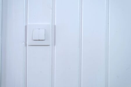Light switch Two Switches On over a white wall