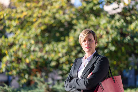 Cheerful businesswoman outside posing with arms crossed